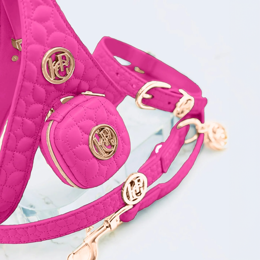 Novalie Pink quilted leather dog harness with gold accents on a light blue background